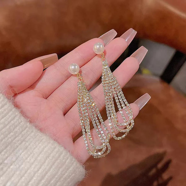 Finoro Pearl Drop Studs showing elegant dangling pearl and crystal earrings on a white silk background.