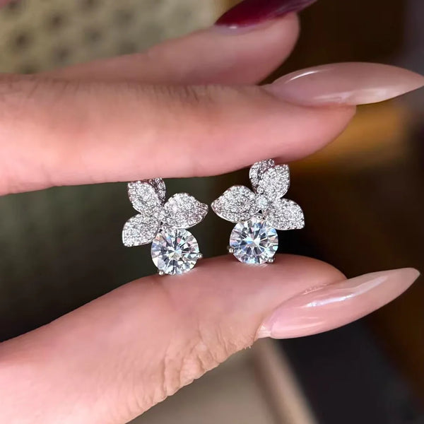Finoro Flora Crystal Studs displaying elegant silver botanical earrings arranged neatly on a grey linen background.