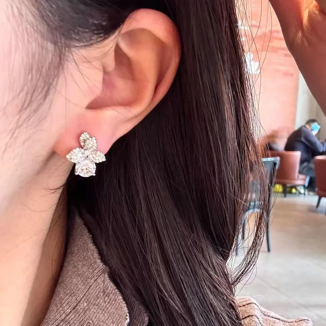 Model wearing the delicate silver Flora Crystal Studs paired beautifully with a minimal silver helix hoop.