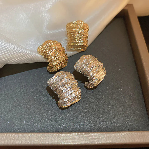 Finoro Bold Gold Studs showing high-polish chunky drop earrings on a neutral linen canvas.